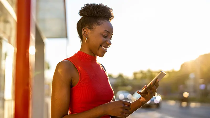 Woman outside U.S. Bank branch looking at mobile phone